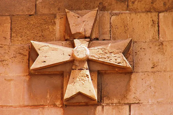 Malta | Jeden z wielu krzyży maltańskich na murach kamienicy Malta | Jeden z wielu krzyży maltańskich na murach kamienicy